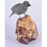 A Carved Hardstone Model of a Bird with Silver Feet Perched on a Rock. 13 cm x 13 cm x 4.5 cm