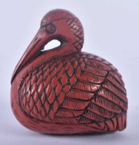 A 19TH CENTURY JAPANESE MEIJI PERIOD RED NEGORO LACQUER NETSUKE formed as a seated bird. 3 cm x 3