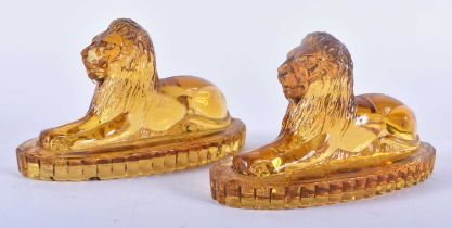 A PAIR OF ANTIQUE MUSTARD YELLOW PRESSED GLASS LIONS. 12 cm x 8 cm.