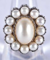 A Silver and Pearl Ring. The central Pearl is surrounded by 12 smaller pearls. Size Q, Stamped