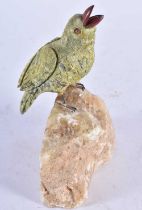 A Carved Hardstone Model of a Bird with Silver Feet Perched on a Rock. 13 cm x 13 cm x 4.5 cm