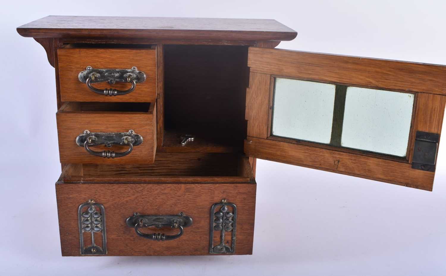 AN ART NOUVEAU OAK SMOKERS CABINET with stylised brass strapwork. 30cm x 28 cm. - Image 2 of 5