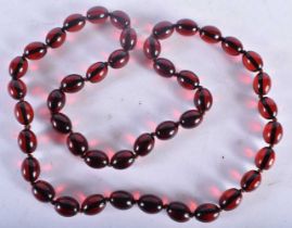 A CHERRY AMBER TYPE RED BEAD NECKLACE. 85 grams. 82 cm long.