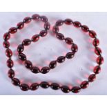 A CHERRY AMBER TYPE RED BEAD NECKLACE. 85 grams. 82 cm long.