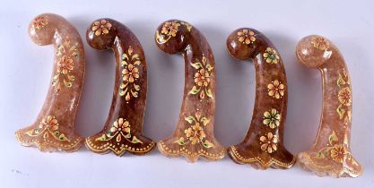 A SET OF FIVE MIDDLE EASTERN QAJAR LACQUER HARDSTONE DAGGER HANDLES overlaid with foliage and vines.