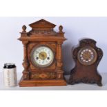 An antique wooden inlaid mantle clock with a porcelain face together with a carved Oak mantle clock