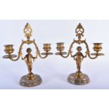 A PAIR OF 19TH CENTURY FRENCH BRONZE FIGURAL CANDLESTICKS formed as nudes upon marble plinths. 23 cm