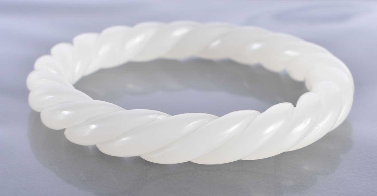 A CHINESE CARVED WHITE JADE TWIST BANGLE 20th Century. 43 grams. 6.5 cm diameter. - Image 2 of 2