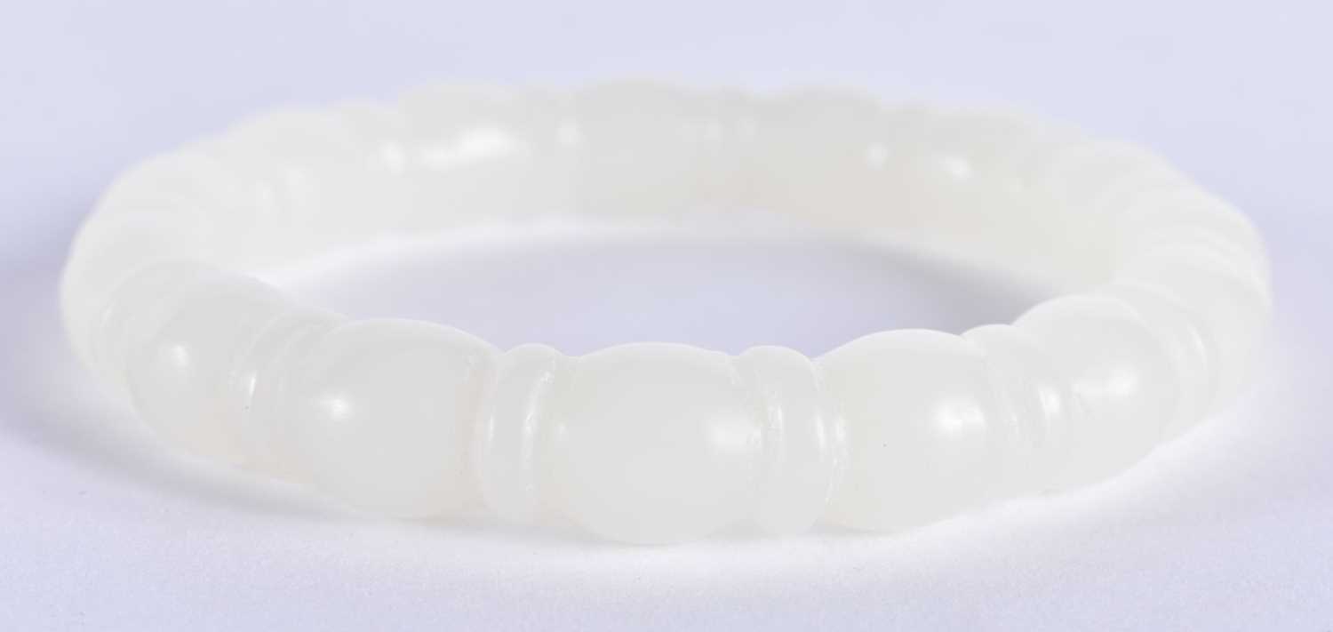 A CHINESE CARVED WHITE JADE RIBBED BANGLE 20th Century. 45.3 grams. 6 cm diameter. - Image 2 of 2