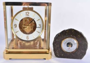 A LECOULTRE BRASS ATMOS CLOCK together with a smaller Cornish stone desk barometer. Largest 24 cm