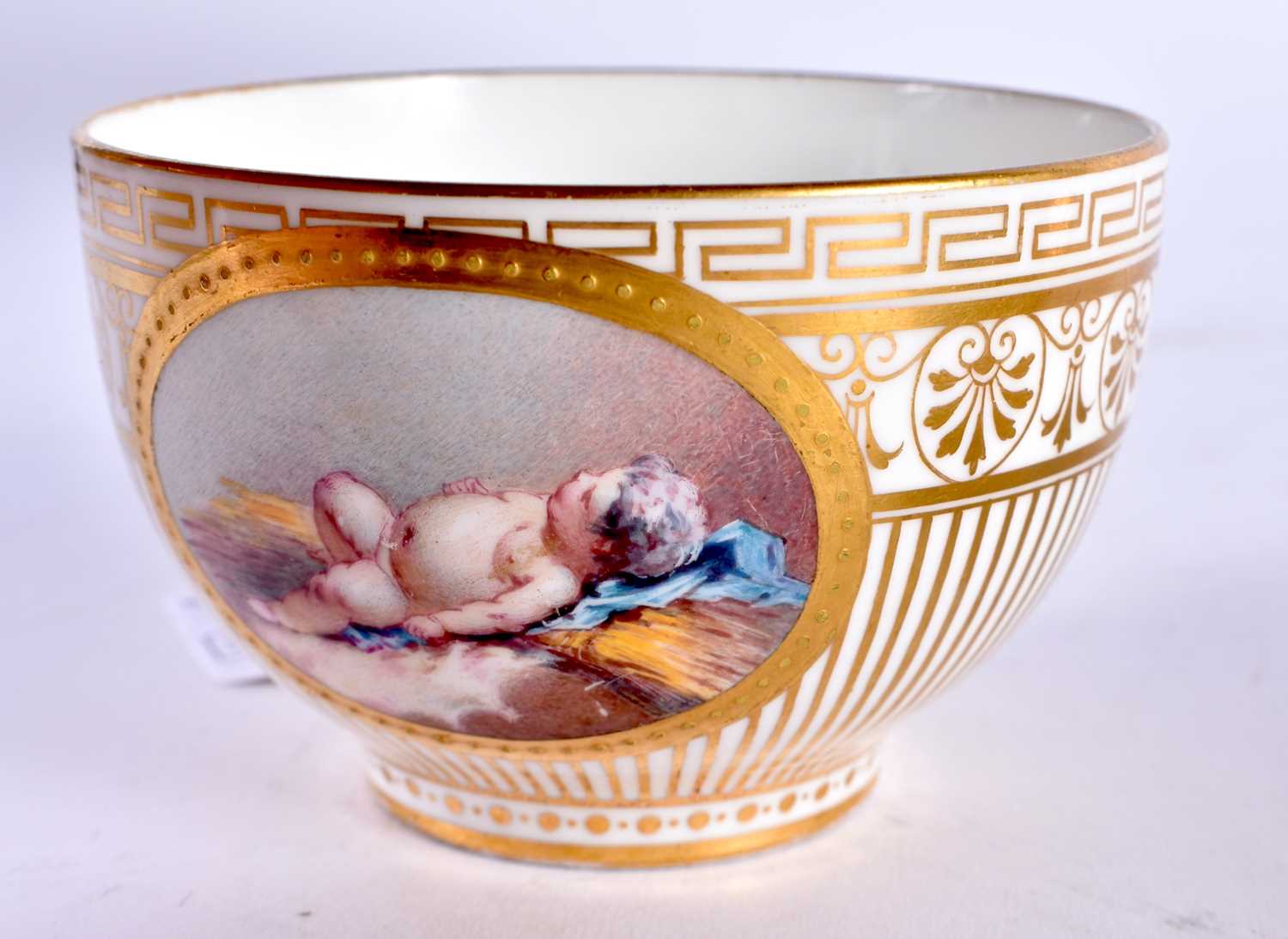 Minton teacup and saucer painted with a naked baby laying on a straw mattress, globe mark, made - Image 9 of 19