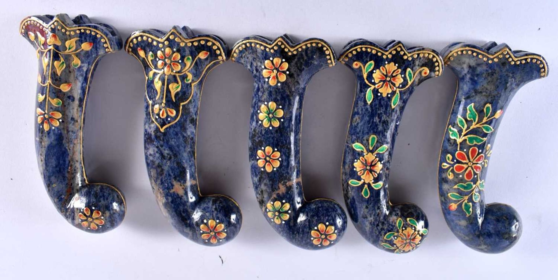 A SET OF FIVE MIDDLE EASTERN QAJAR LACQUER HARDSTONE DAGGER HANDLES overlaid with foliage and vines.