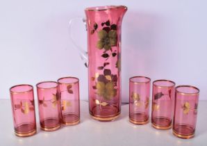 A 1960's Cranberry glass and gilt decorated Pitcher with 6 glasses 32 x 10 cm (7)