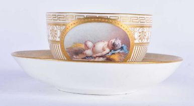 Minton teacup and saucer painted with a naked baby laying on a straw mattress, globe mark, made