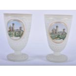 A PAIR OF ANTIQUE OPALINE JEWELLED GLASS BEAKERS painted with German landmarks. 11cm x 6 cm.