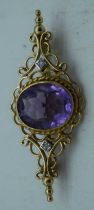 A YELLOW METAL AMETHYST BROOCH. 4.25 grams. 4.25cm x 1.75 cm.