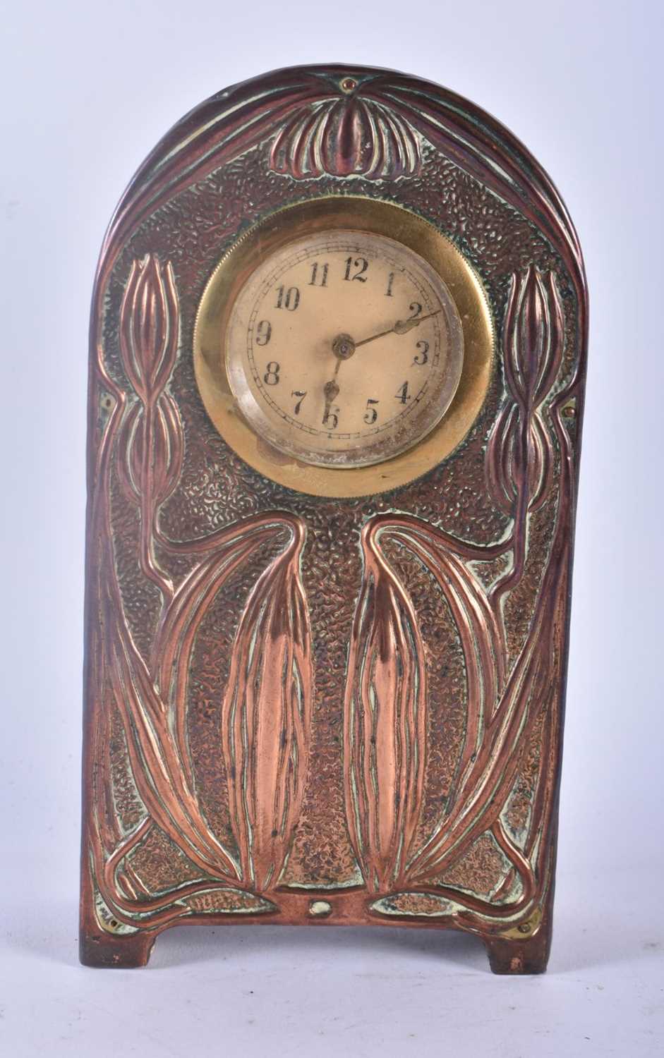 AN ART NOUVEAU COPPER REPOUSSE MANTEL CLOCK decorated in relief with floral vines and drapes. 20