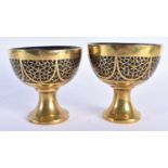 A PAIR OF 19TH CENTURY ANGLO INDIAN BRONZE OVERLAID CARVED COCONUT CUPS decorated with motifs. 8