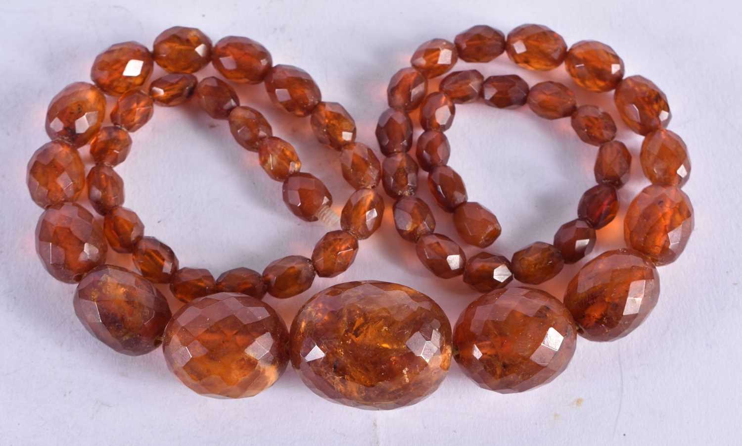 A Faceted Amber Bead Necklace. 58cm long, largest Bead 20mm, weight 35g