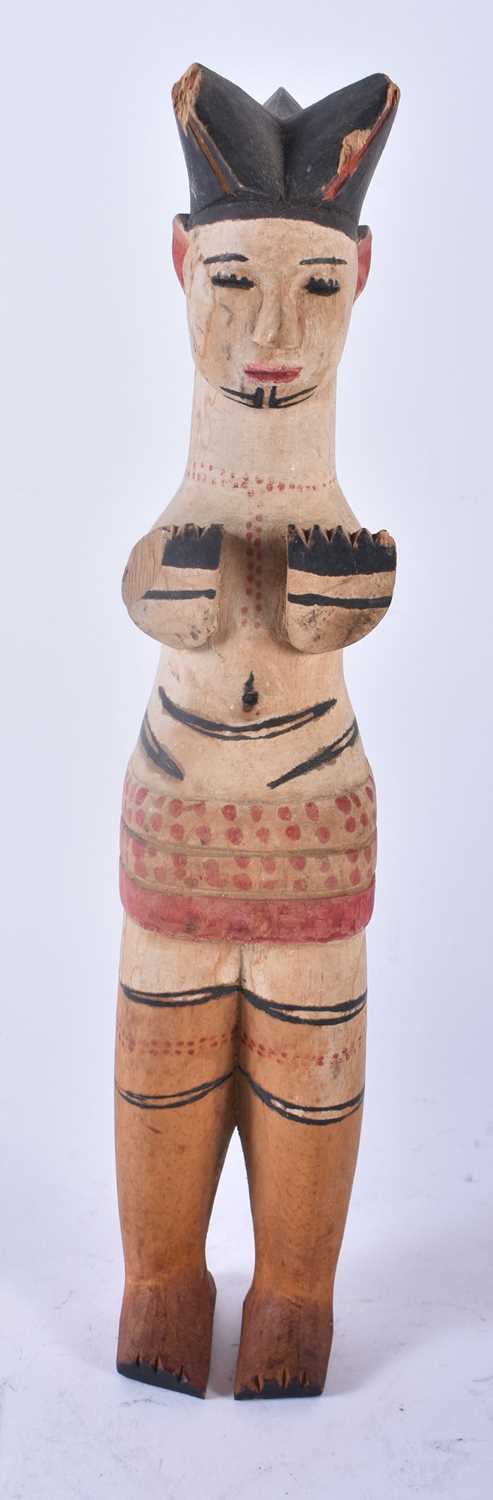 AN UNUSUAL AFRICAN TRIBAL PAINTED WOOD FIGURE modelled with hands covering her breasts. 30cm high.