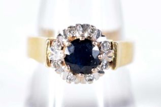An 18 Carat Gold Ring Set with a Sapphire surrounded by Diamonds. Hallmarked Birmingham 1975, Size