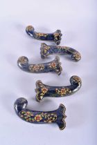 A SET OF FIVE MIDDLE EASTERN QAJAR LACQUER HARDSTONE DAGGER HANDLES overlaid with foliage and vines.