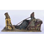 A COLD PAINTED BRONZE FIGURE OF A SEATED MALE beside a nude female. 18cm x 8 cm.