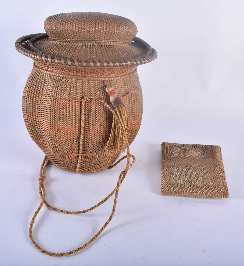 AN UNUSUALLY FINE TRIBAL CARVED WICKER BASKET AND COVER together with a similar wicker sliding pouch