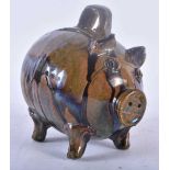 A CHARMING ANTIQUE FOLK ART TREACLE GLAZED POTTERY PIG MONEY BOX. 15 cm x 12 cm.