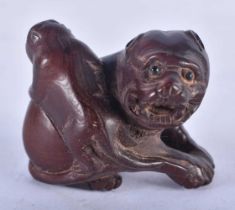 A Japanese Hardwood Netsuke carved as a dog with a Pup on its back. 4cm x 4cm