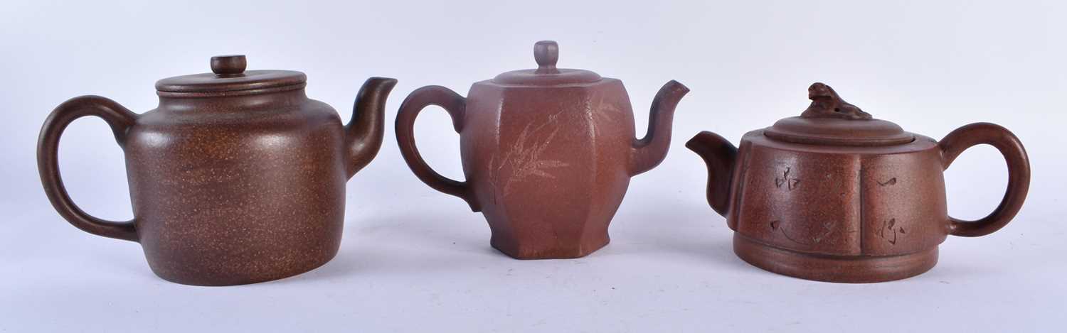 THREE CHINESE YIXING POTTERY TEAPOTS AND COVERS possibly Republican period. Largest 20 cm wide. (3)