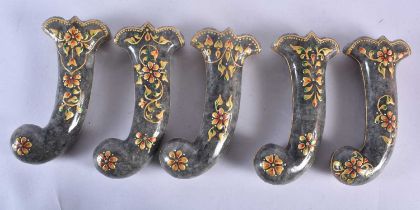 A SET OF FIVE MIDDLE EASTERN QAJAR LACQUER HARDSTONE DAGGER HANDLES overlaid with foliage and vines.