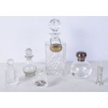 A collection of perfume bottles one with a silver top together with a Decanter with a silver label