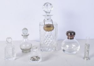 A collection of perfume bottles one with a silver top together with a Decanter with a silver label