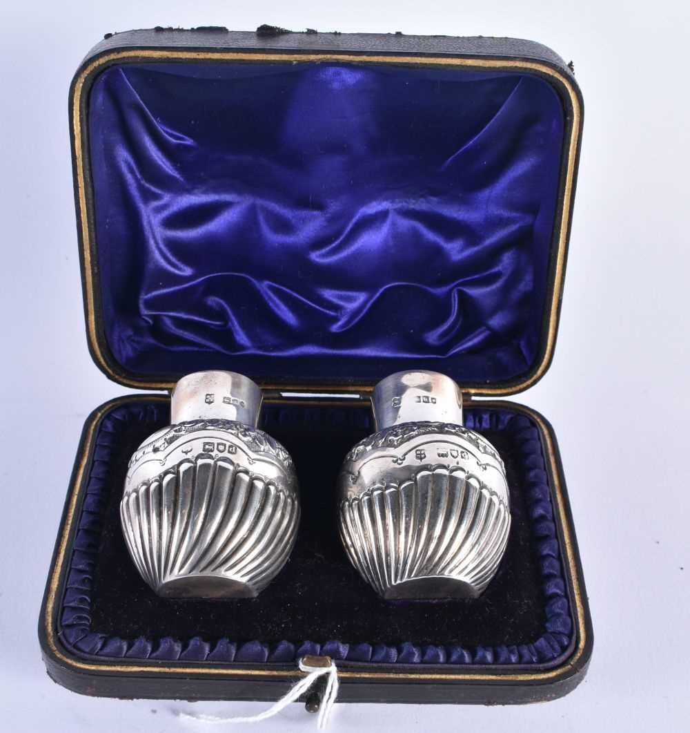 A CASED PAIR OF SILVER CONDIMENTS. London 1899. 71.4 grams. 6 cm x 4.5 cm.