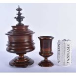 A LARGE ANTIQUE TREEN CARVED WOOD VASE AND COVER together with a similar vase. Largest 27cm high.