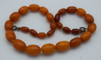 AN AMBER NECKLACE. 17 grams. 36 cm long, largest bead 1.75 cm x 1 cm.