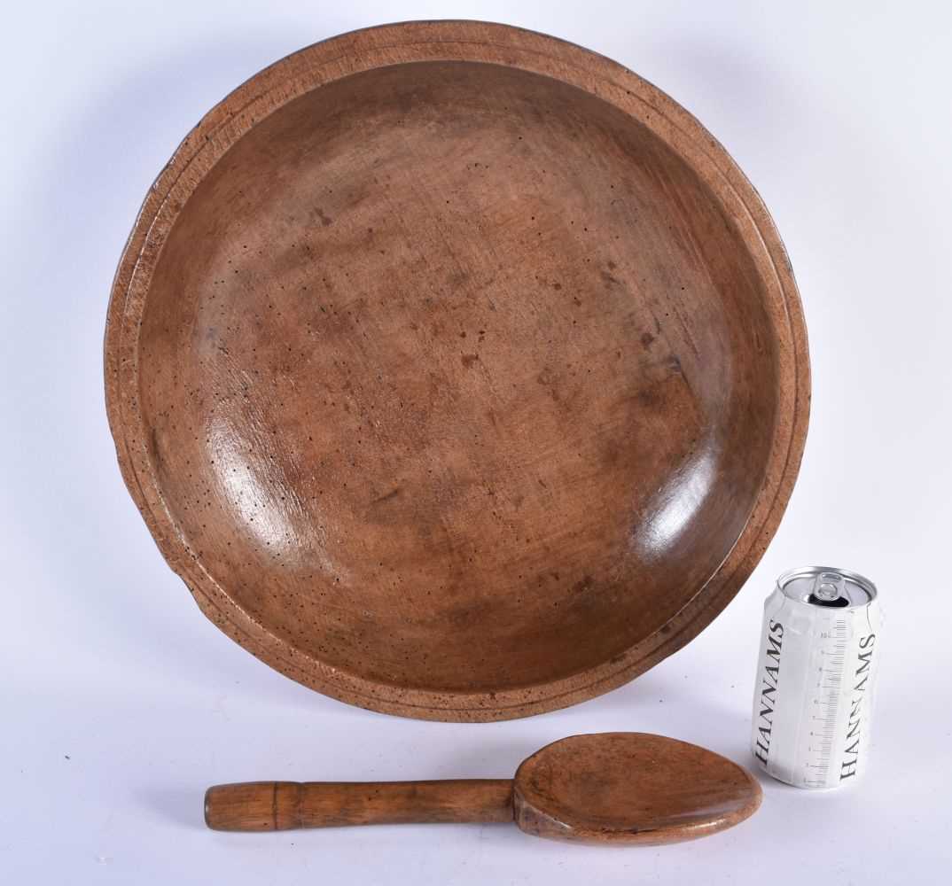 A CARVED DAIRY WOOD TREEN BUTTER BOWL AND SPOON. Bowl 40 cm diameter. (2)