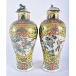 A PAIR OF 19TH CENTURY CHINESE FAMILLE JAUNE PORCELAIN VASES AND COVERS Qing, painted with figures