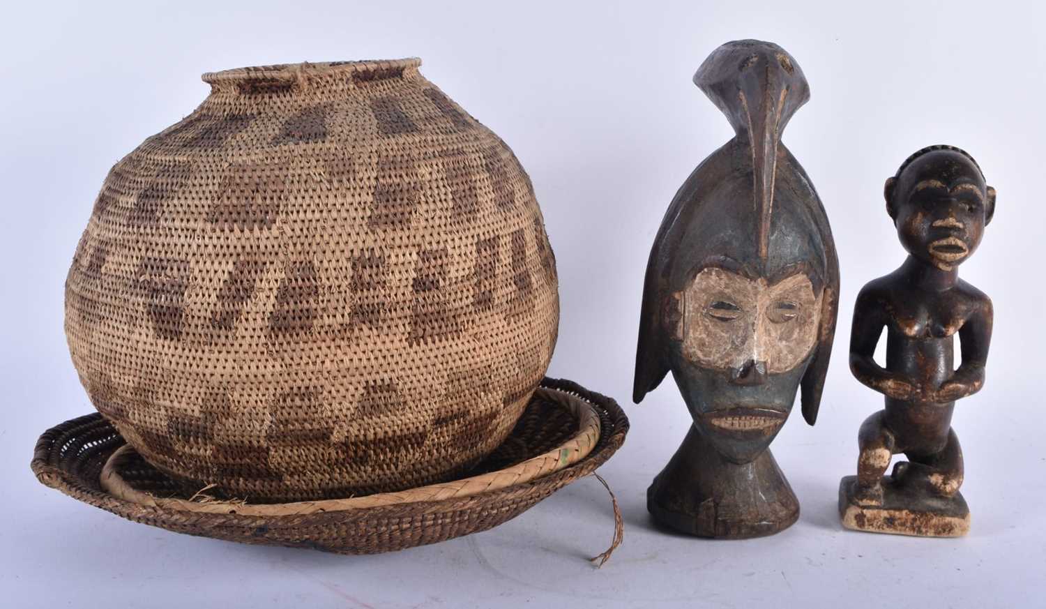 A TRIBAL BIRD HEAD WOOD MASK together with another African figure. Largest 26cm high. (5)