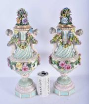 A LARGE PAIR OF 19TH CENTURY GERMAN PORCELAIN TWIN HANDLED VASES AND COVERS modelled as putti