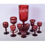 A collection of 1950's Bohemian Ruby wine glasses engraved with a Floral pattern together with a