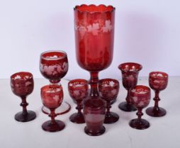 A collection of 1950's Bohemian Ruby wine glasses engraved with a Floral pattern together with a