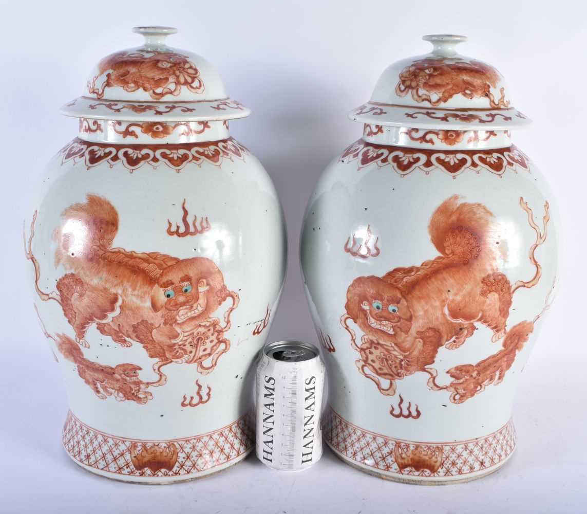 A LARGE PAIR OF CHINESE QING DYNASTY IRON RED PAINTED GINGER JARS AND COVERS painted with buddhistic