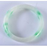 A CHINESE CARVED JADEITE BANGLE 20th Century. 7 cm diameter.