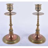 A PAIR OF ARTS AND CRAFTS BRONZE AND COPPER CANDLESTICKS decorated with floral sprays and motifs. 19