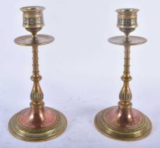 A PAIR OF ARTS AND CRAFTS BRONZE AND COPPER CANDLESTICKS decorated with floral sprays and motifs. 19