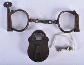 A PAIR OF ANTIQUE HANDCUFFS together with a similar padlock. Largest 24 cm long. (3)