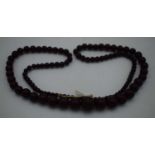 A DEEP RED CHERRY AMBER TYPE NECKLACE. 37 grams. 76 cm long, largest bead 1 cm diameter.