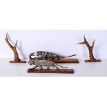 two carved horn tigers set on wooden Plinths together with two small Deer Antler wall hangings